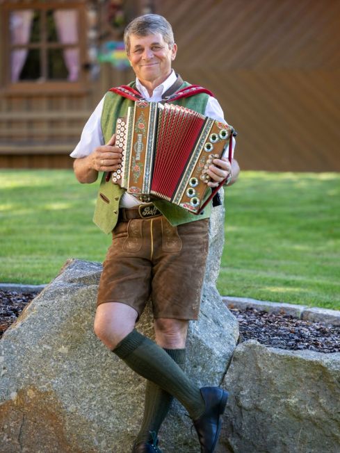Bäff mit Harmonika sitzend auf einem Stein