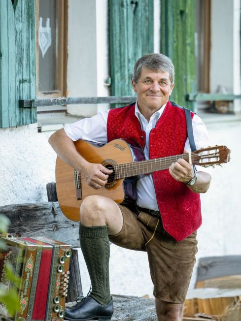 Bäff mit Gitarre auf einer Holzbank